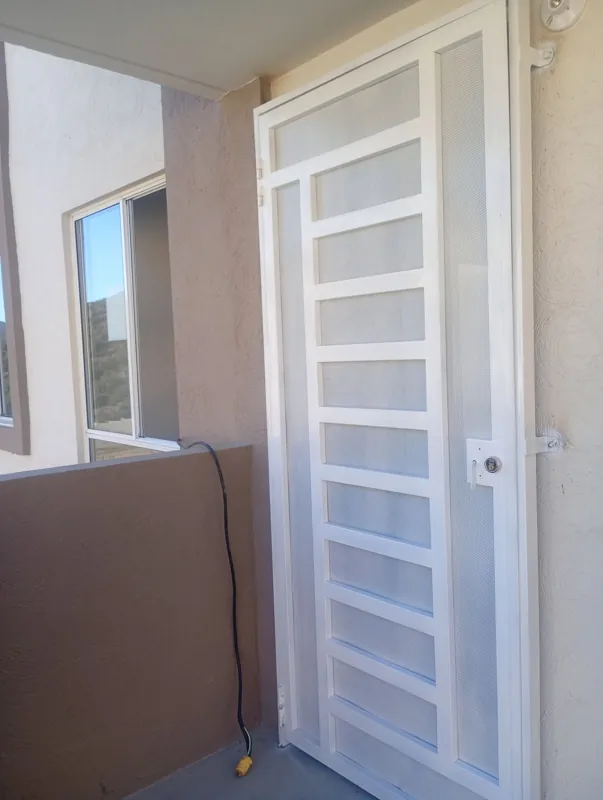 Puerta de herrería blanca con malla y divisiones horizontales para departamento